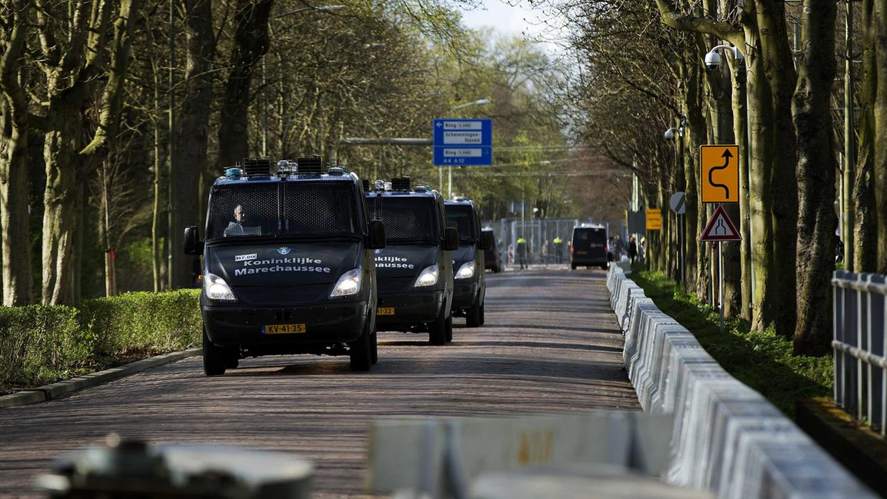 Fahrzeuge der royalen Militärpolizei fahren im Konvoi auf einer gesperrten Straße in Den Haag, Niederlanden.