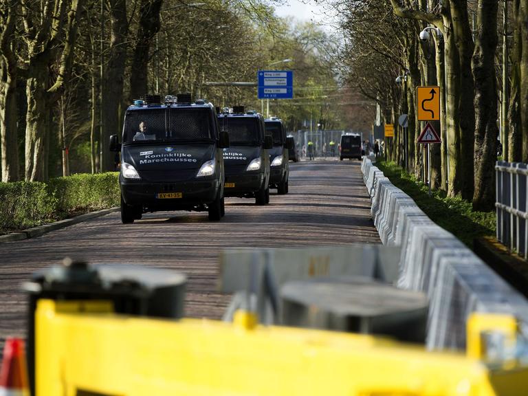 Fahrzeuge der royalen Militärpolizei fahren im Konvoi auf einer gesperrten Straße in Den Haag, Niederlanden.