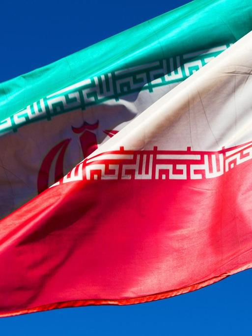 Iranische Flagge weht vor blauem Himmel