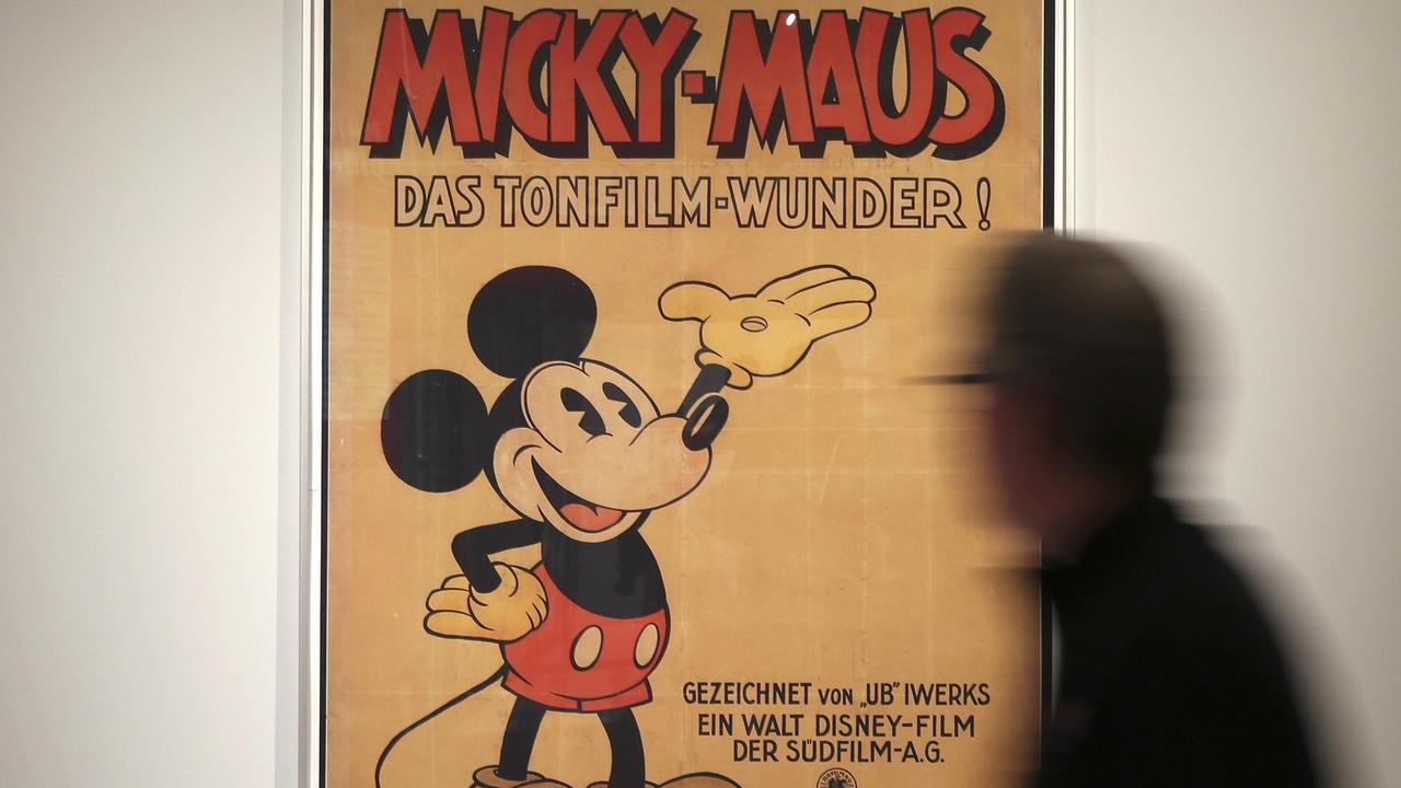 Ein Mann betrachtet am 19.12.2013 in Hamburg im Museum für Kunst und Gewerbe ein Plakat mit einer Micky-Maus Figur.