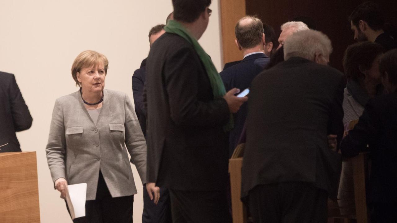 Bundeskanzlerin Angela Merkel (CDU) geht am Rande der Jamaika-Sondierungen von Union, FDP und Grünen in Berlin über einen Flur der Landesvertretung von Baden-Württemberg.