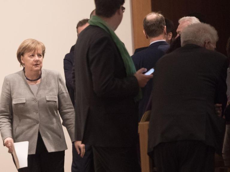 Bundeskanzlerin Angela Merkel (CDU) geht am Rande der Jamaika-Sondierungen von Union, FDP und Grünen in Berlin über einen Flur der Landesvertretung von Baden-Württemberg.