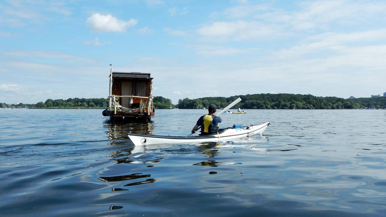 Ein Kajak und ein Hausboot unterwegs auf dem Wasser, zwischen Havel und Stößensee in Berlin-Spandau.