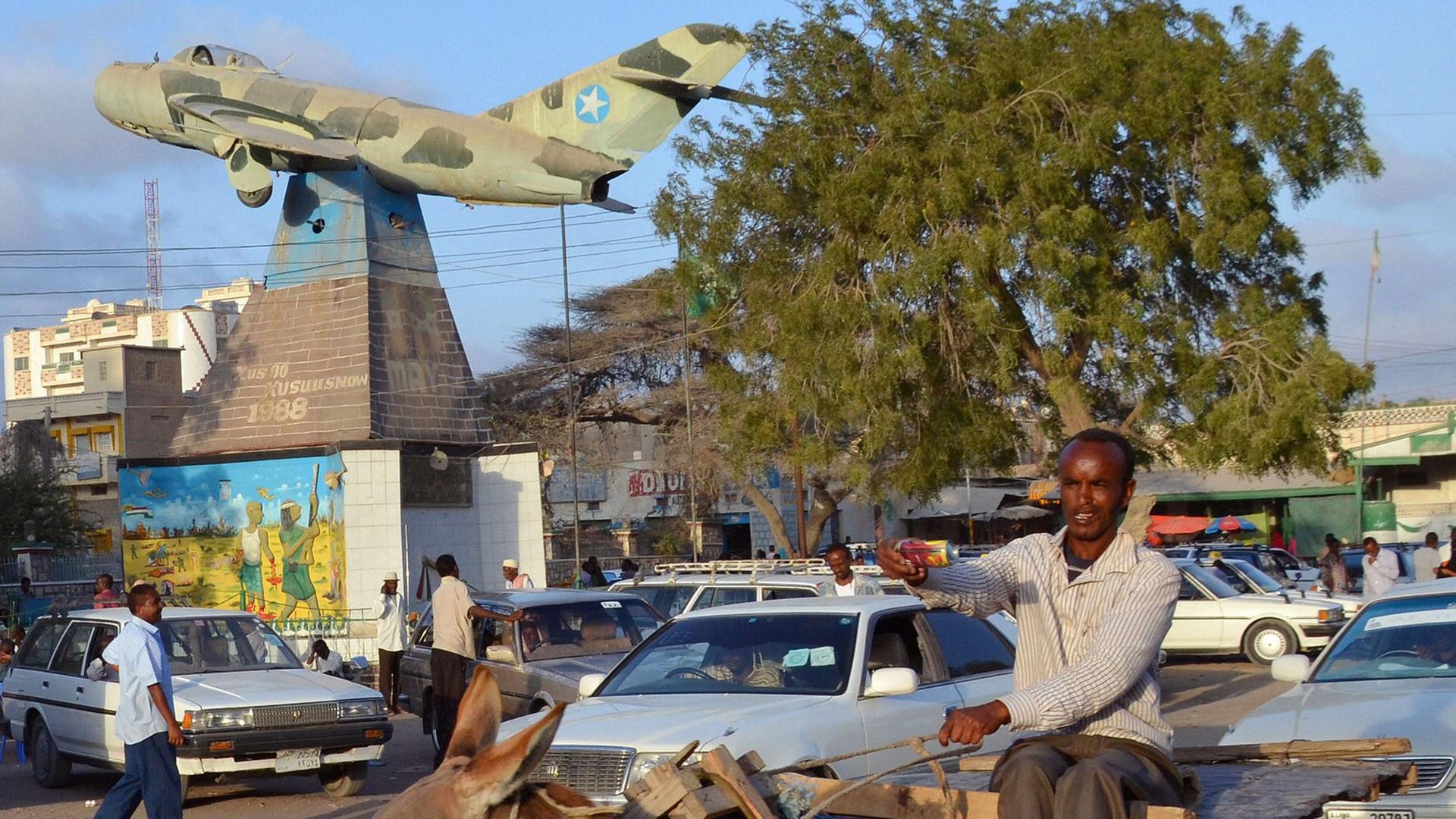 Die somalische Hauptstadt Hargeisa. Die Ein Mann sitzt auf einem Esel und reitet durch eine befahrene Straße.