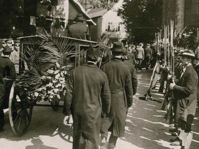 Bei den Beisetzungsfeierlichkeiten für Matthias Erzberger passiert der Leichenwagen eine Ehrenformation Schwarzwälder Schützen. Foto, August 1921 (Robert Sennecke)