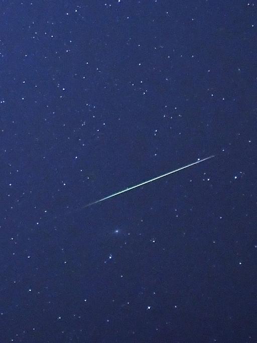 Eine Sternschnuppe leuchtet am Nachthimmel über Halle/Saale (Sachsen-Anhalt) auf.