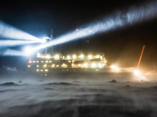 Das Forschungsschiff Polarstern während einer Eisstation mit starken Winden und einer starken Schneedrift.