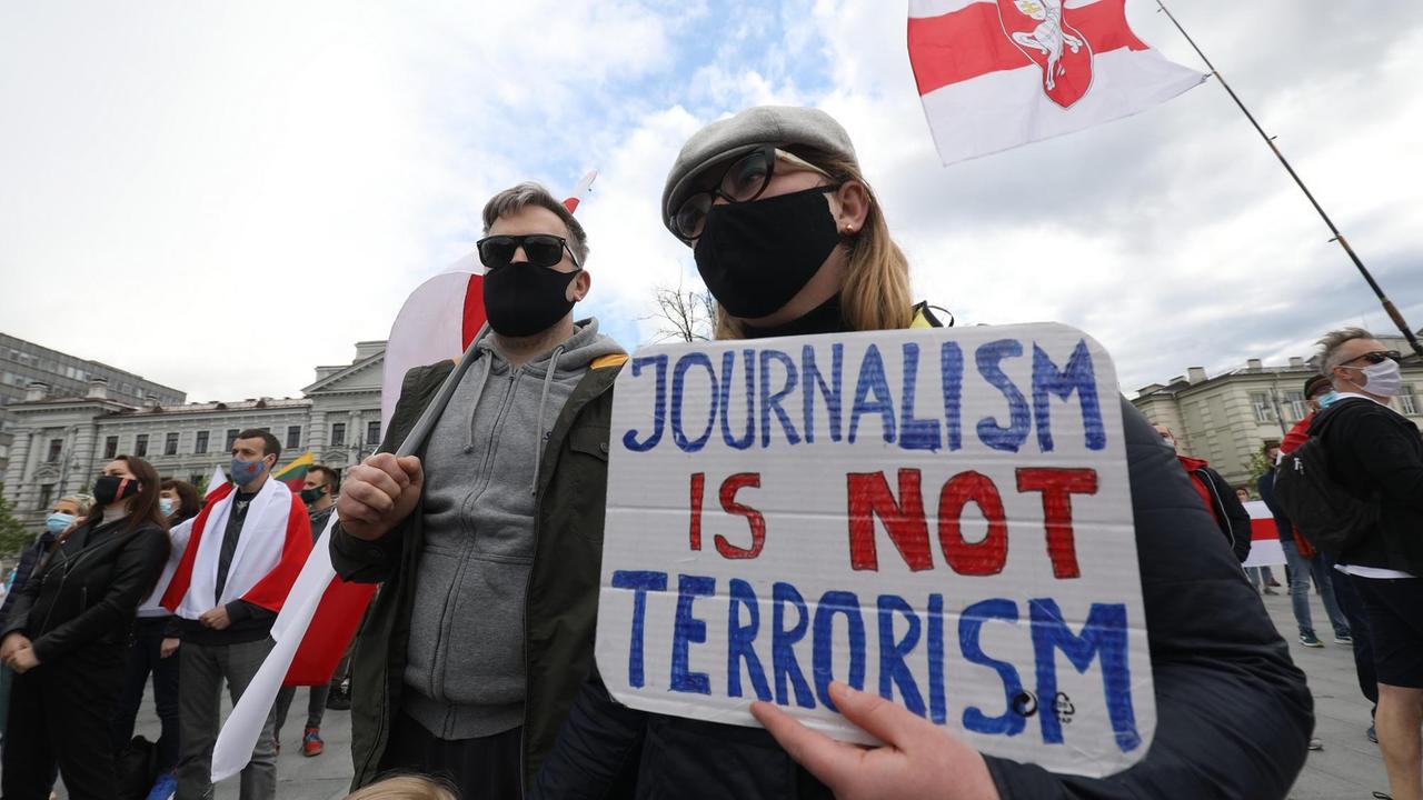 Protestierende halten ein Schild mit der Aufschrift: "Journalism ist not Terrorism / Journalismus ist kein Terrorismus".