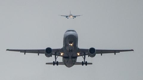 Ein Airbus 320 von Lufthansa startet vom Flughafen Hannover-Langenhagen während dahinter ein Airbus 319 von Swiss im Landeanflug ist.
