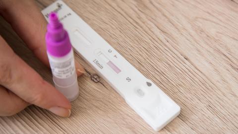 Eine Frau führt einen Corona-Selbsttest durch