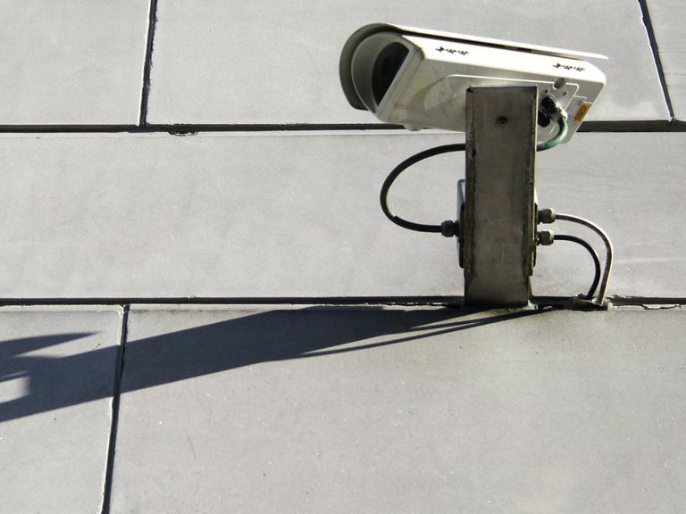 Eine Überwachungskamera hängt an der Fassade der Bayerischen Staatskanzlei in München.