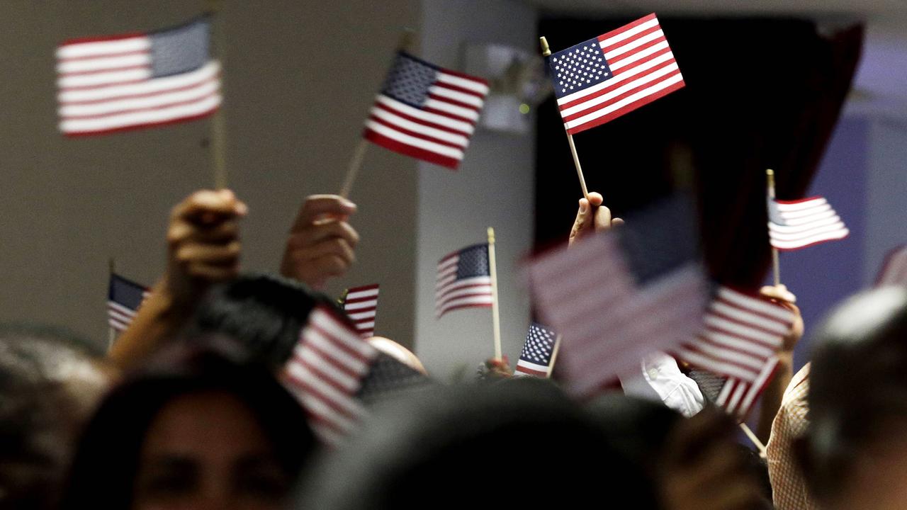 Menschen schingen kleine US-Flaggen bei einer Einbürgerungsveranstaltung im Juli 2013 in New York City.