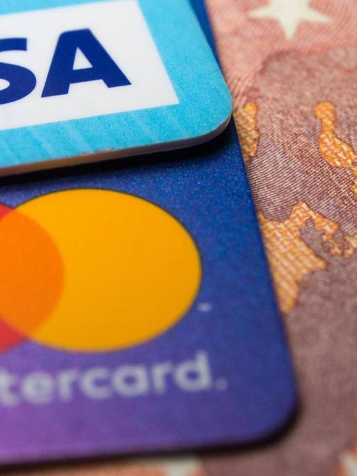 Eine Visa- und eine Mastercard-Kreditkarte auf einem 50-Euro-Schein