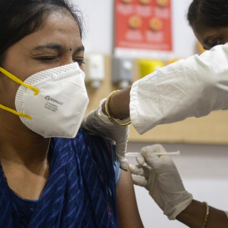 Eine Mitarbeiterin der Gesundheitsbehörde verabreicht einer Krankenhausangestellten im Sunshine Hospital im indischen Hyderabad eine Impfung gegen Covid-19