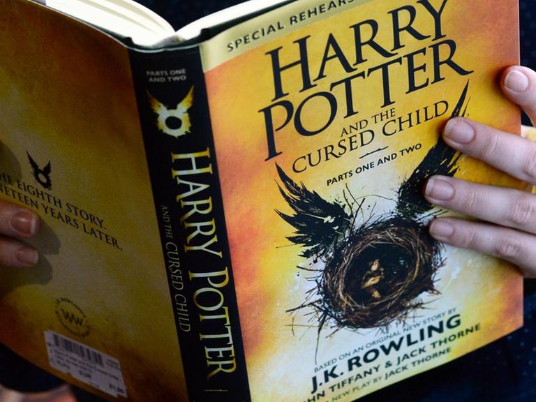 Eine Frau hält das Buch "Harry Potter and the Cursed Child Parts I & II" von Joanne K. Rowling am 25.08.2016 in Berlin im "English Bookshop" im Kulturkaufhaus Dussmann in den Händen.
