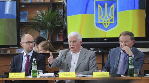 Der ukrainische Regierungschef Arseni Jazenjuk sitzt an einem Tisch mit den den Ex-Präsidenten Leonid Kutschma und Leonid Krawtschuk (v.l.n.r.).