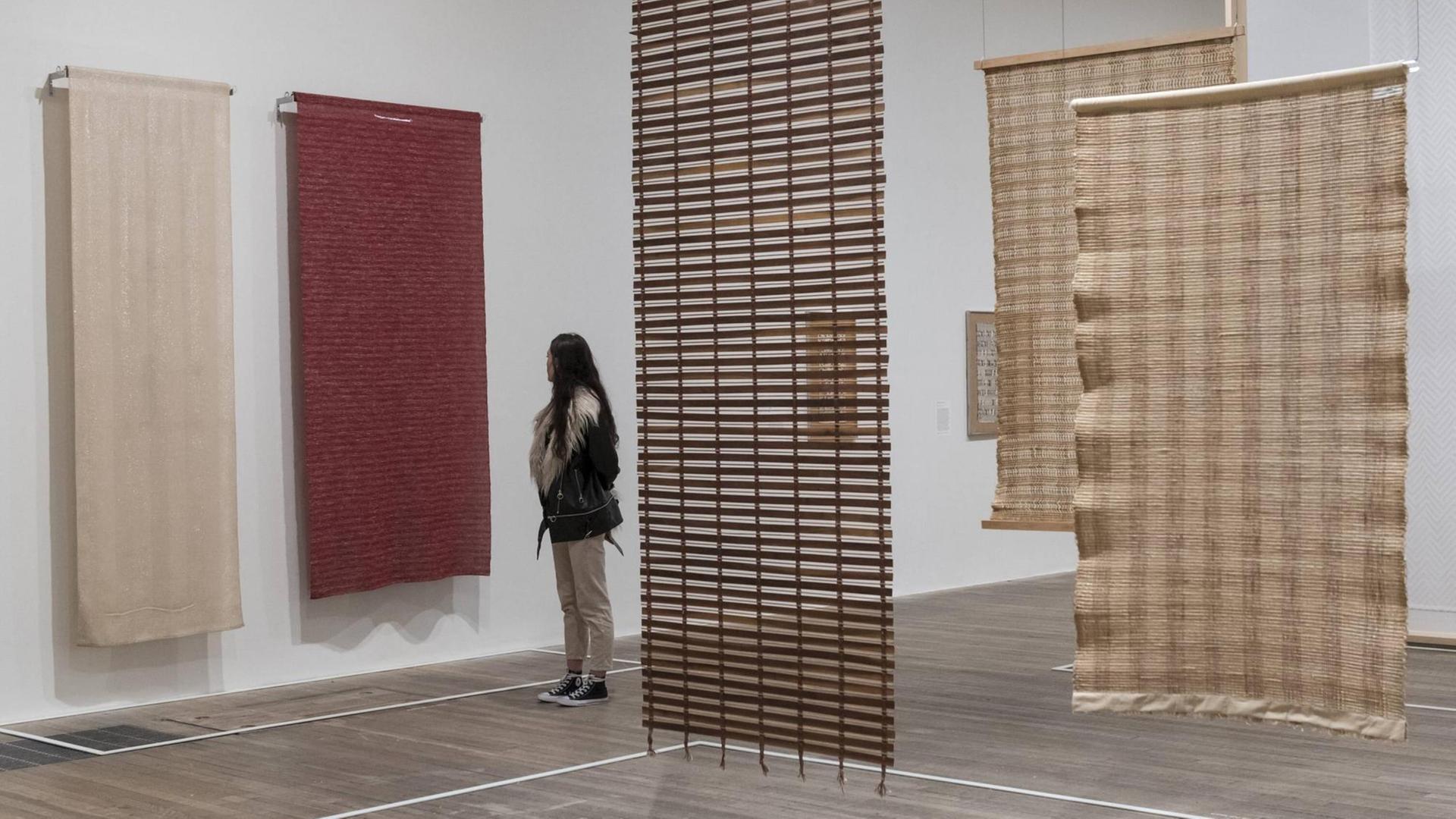 October 9, 2018 - London, UK - Eine Museumsbesucherin schaut Textilarbeiten der deutschen Künstlerin Anni Albers aus den Jahren 1935 und 1949 in einer Ausstellung in der Tate Modern in London an.
