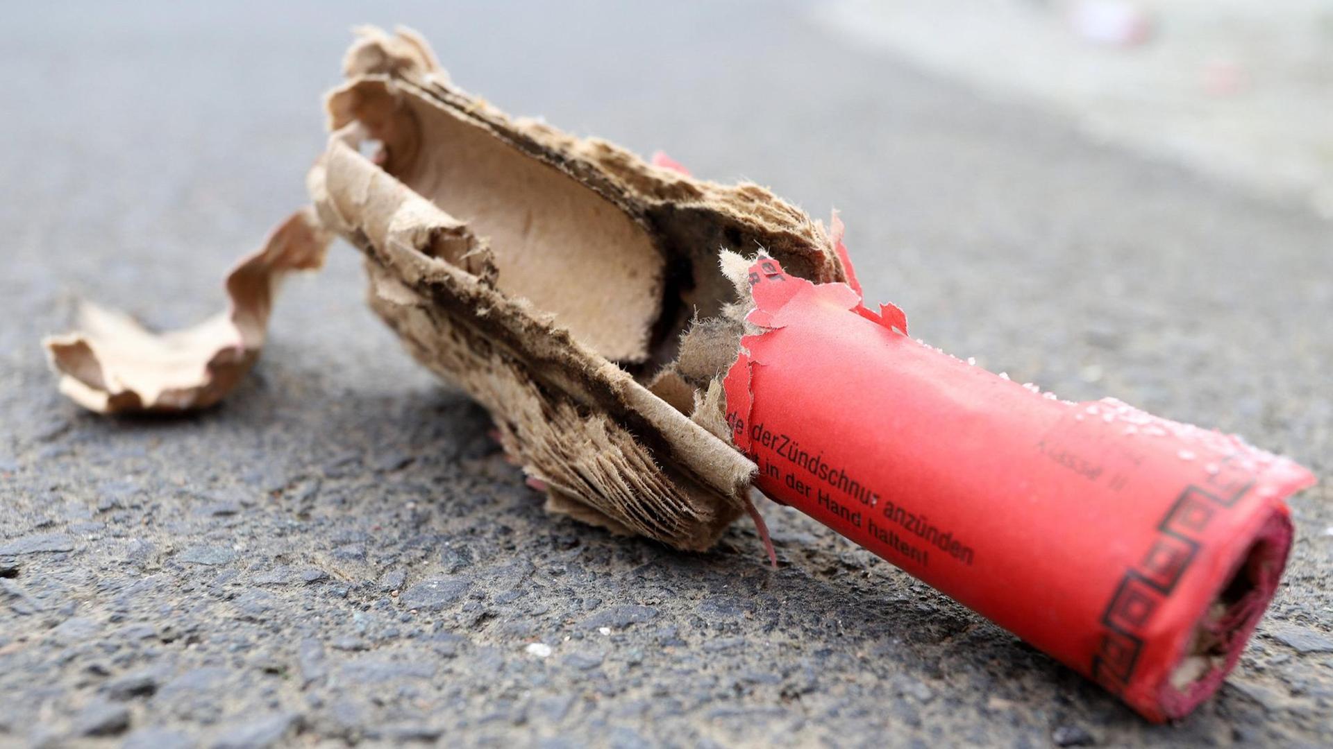 Ein explodierter roter Böller liegt auf der Straße.