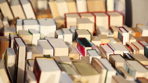 Bücher stehen in einer Kiste vor einem Antiquariat in Berlin