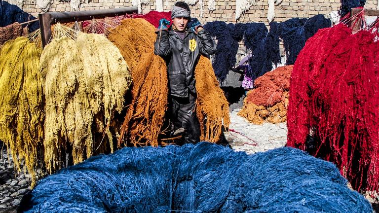 Ein junger Afghane produziert Teppiche.