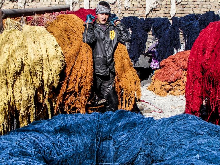 Ein junger Afghane produziert Teppiche.