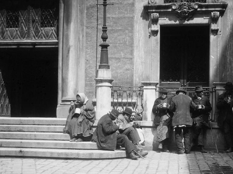 Bettler bei der Ausspeisung vor der Jesuitenkirche in Wien. Photographie um 1900