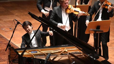 Ein Pianist spielt mit vollem Einsatz an einem Flügel