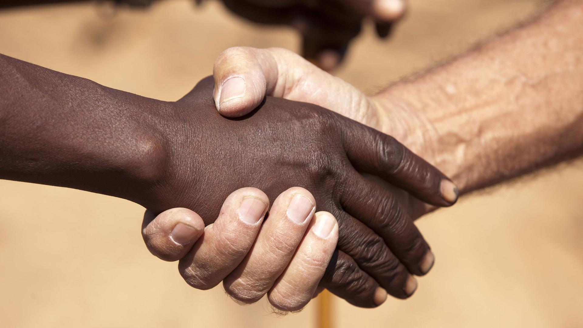 Ein Handschlag zwischen einem Schwarzen und Weißen.