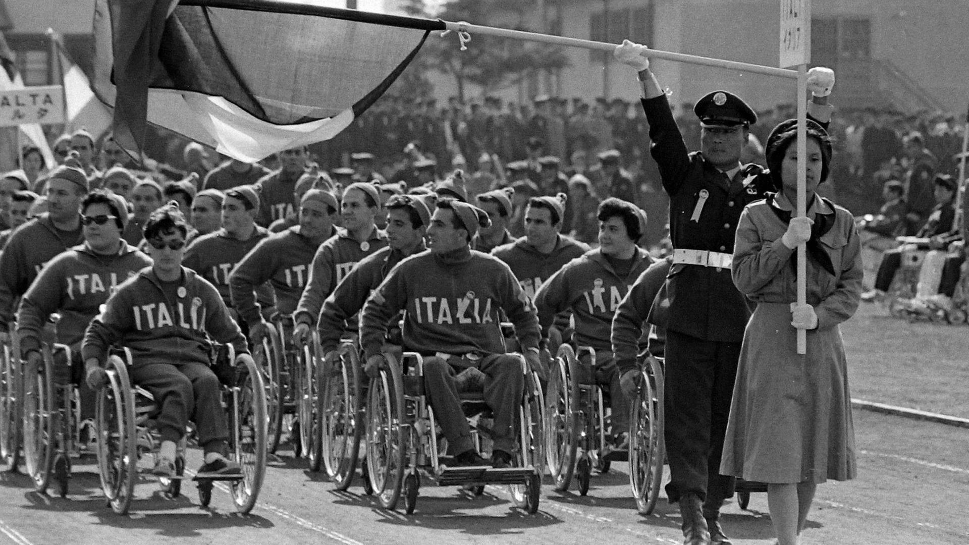Schwarz-weiß-Aufnahme von der Eröffnungsfeier 1964, das italienische Team in Rollstühlen