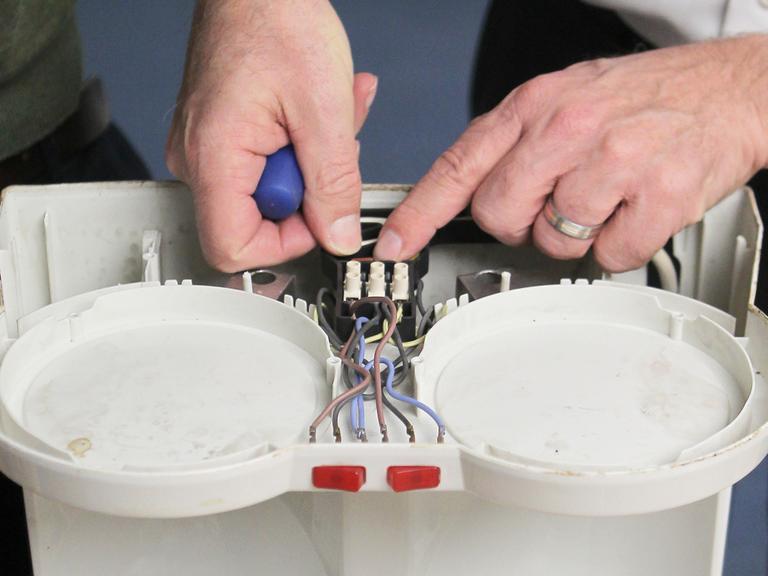 Zwei Hobby-Experten bei der Reparatur einer Kaffeemaschine