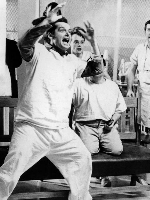 Der US-amerikanische Schauspieler Jack Nicholson (M) in einer Szene des Milos-Forman-Films "Einer flog über das Kuckucksnest" aus dem Jahr 1979. Nicholson spielt den Strafgefangenen McMurphy, der - um einem Arbeitslager zu entgehen - "verrückt" spielt und sich in eine Nervenheilanstalt einweisen läßt. Zunächst kann er Spaß und Abwechslung in den monotonen und oft unmenschlichen Alltag der Heiminsassen bringen, doch schließlich scheitert er und wird durch eine Gehirnoperation seiner Persönlichkeit beraubt. Der Film, entstanden nach dem Bestseller-Roman von Ken Kesey, wurde 1976 mit vier Oscars ausgezeichnet (Regie, bester Film, beste/r Hauptdarsteller/in). |