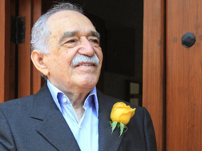 Der kolumbianische Schriftsteller und Literaturnobelpreisträger Gabriel García Márquez steht im März 2014 mit einer gelben Rose am Revers vor einer Holztür. Er starb im Monat darauf.