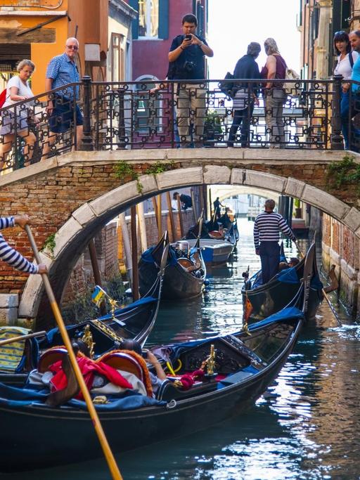 Touristen in einer Gondel erkunden Venedig.