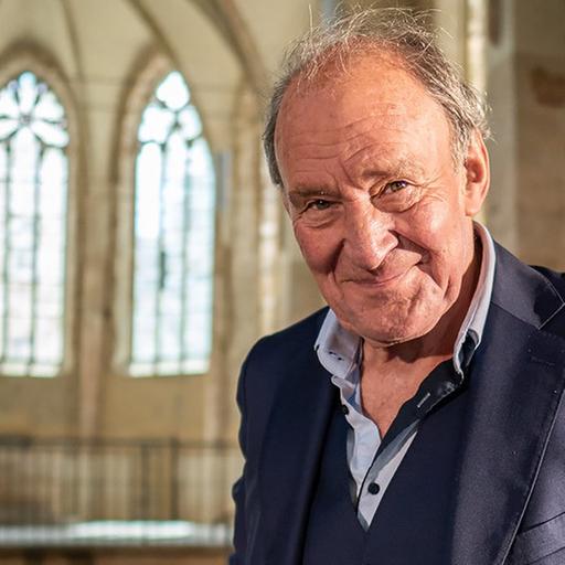 Der Schauspieler Michael Mendl steht in Zeitz in einer Kirche und verkündet das kommende Programm der Mendl-Festspiele.