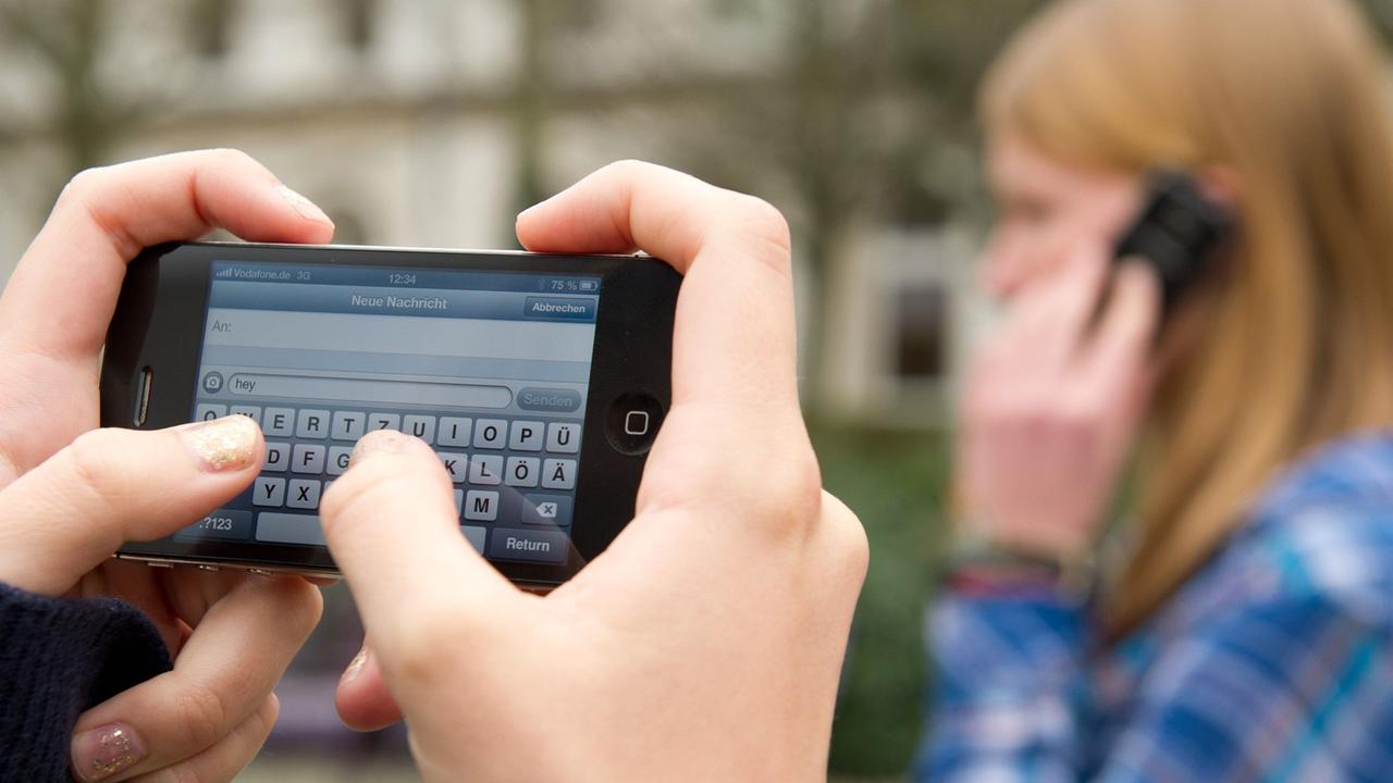 Schüler schreiben SMS und telefonieren am 22.04.2013 auf einem Schulhof in Braunschweig (Niedersachsen). 