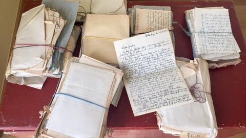 Handschriftliche Briefe ihres Großvaters Hermann Pirich, gestapelt auf der roten Kiste