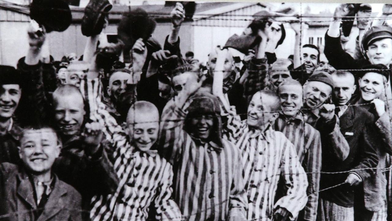 Häftlinge des KZ Dachau jubeln bei ihrer Befreiung durch amerikanische Truppen am 29. April 1945