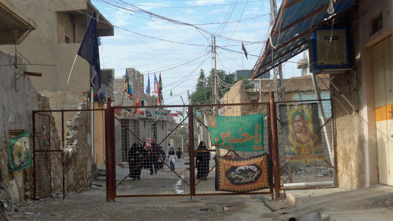 Ein abgeriegelter und bewachter Wohnbezirk der schiitisch-turmkenischen Minderheit in Duskhurmatu nahe Kirkuk im Nordirak. Am Gitter ein Bild des schiitischen Stammvaters Ali.