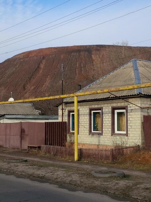 Mehrere Häuser stehen vor einem Berg an einer Straße. Mehrere Häuser stehen vor einem Berg an einer Straße.