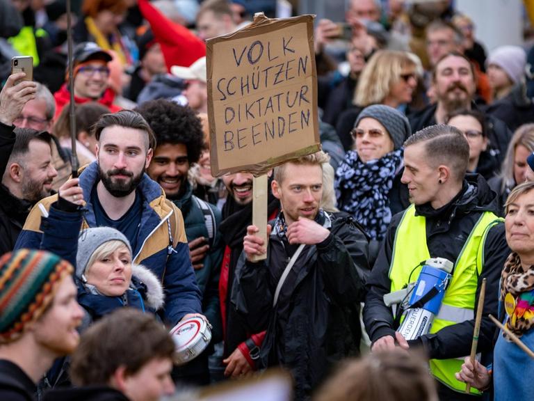 Demonstration gegen die Corona Auflagen. Teilnehmer auf einer Kundgebung auf dem Friedrichsplatz in Kassel. Sie stehen eng beieinander und tragen keine Masken. 20. März 2021.