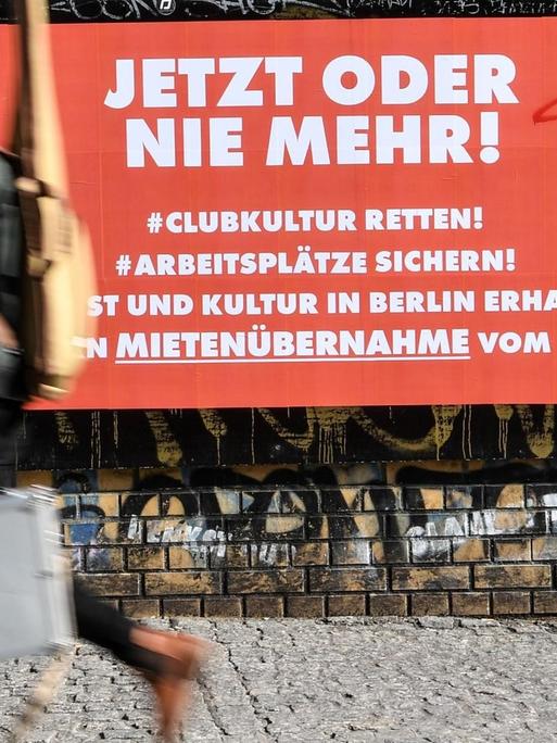 Ein Mann passiert ein Plakat mit der Aufschrift "Jetzt oder nie mehr! #Clubkultur retten!"