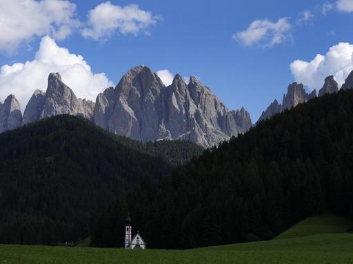 Clouds hang over the St. Johann chapel and the Dolomites mountains in St. Maddalena, St. Magdalena, in Val di Funes (Villnoess), in northern Italian province of South Tyrol, Italy, Friday, Aug. 20, 2021. (AP Photo/Matthias Schrader)