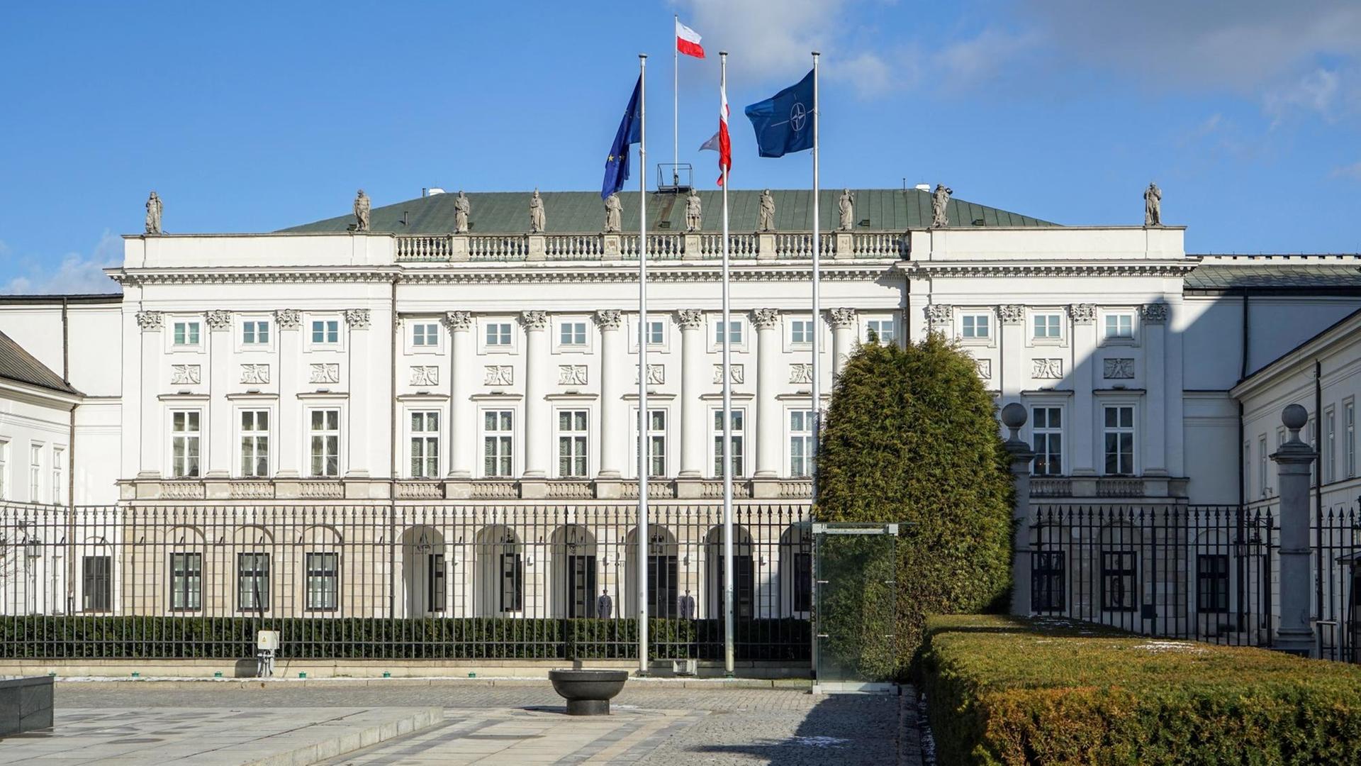 Blick auf das helle klassizistische Gebäude hinter einem Zaun. Darüber blauer Himmel. Blick auf das helle klassizistische Gebäude hinter einem Zaun. Darüber blauer Himmel.