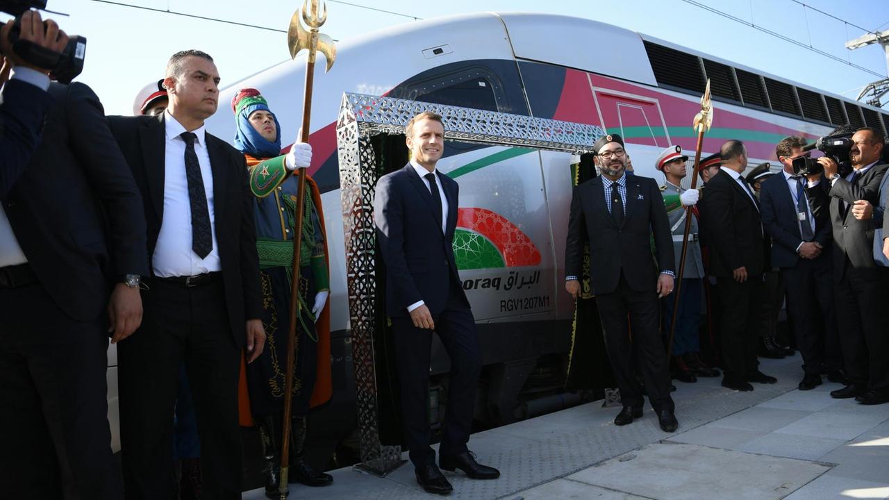 Mohammed VI. und Emmanuel Macron stehen vor einem Hochgeschwindigkeitszug.