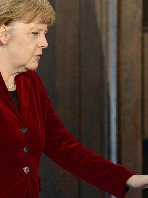Angela Merkel geht an einer US-Flagge vorbei