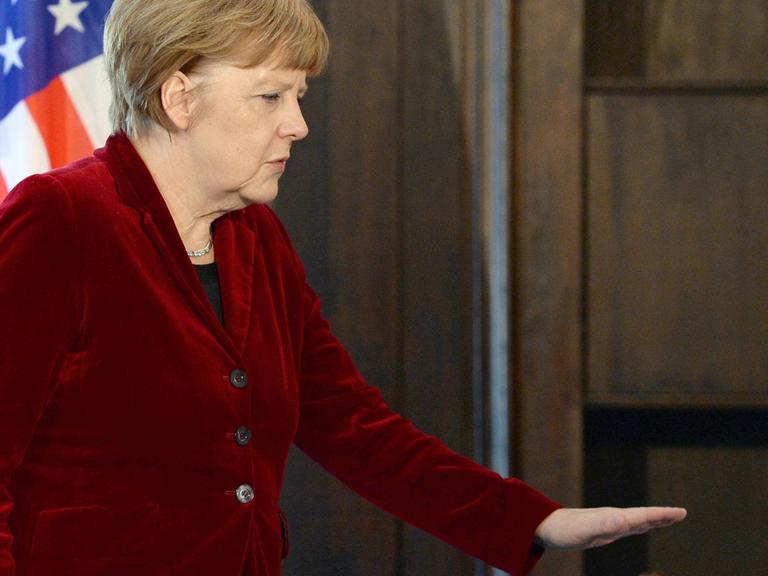 Angela Merkel geht an einer US-Flagge vorbei