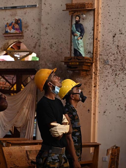 Sicherheitspersonal untersucht das Innere der Kirche St. Sebastian in Negombo am 22. April 2019, einen Tag nachdem die Kirche in einer Serie von Bombenattentaten getroffen wurde.