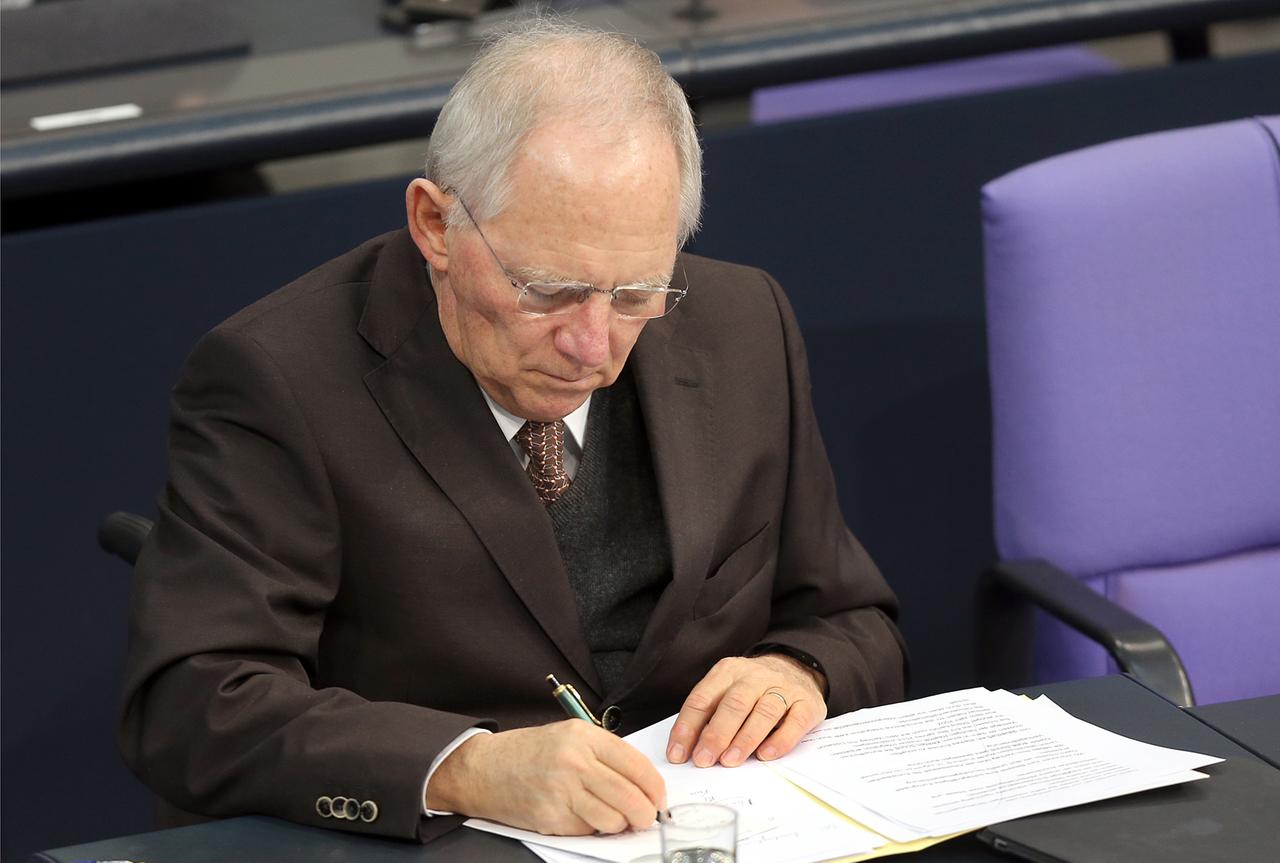 Der Bundesfinanzminister Wolfgang Schäuble (CDU) schreibt am 30.01.2014 während der Debatte im Deutschen Bundestag in Berlin in seinen Unterlagen.