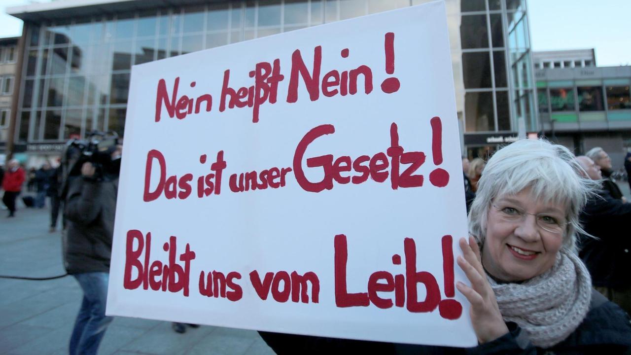 Eine Demonstrantin hält während einer Demonstration nach den sexuellen Übergriffen in der Silvesternacht am 09.01.2016 in Köln (Nordrhein-Westfalen) vor dem Hauptbahnhof ein Schild mit der Aufschrift "Nein heißt Nein!"