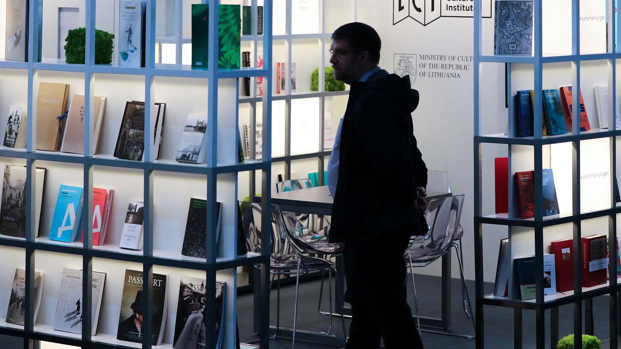 Ein Besucher der Leipziger Buchmesse studiert das Angebot am Stand von Litauen.
